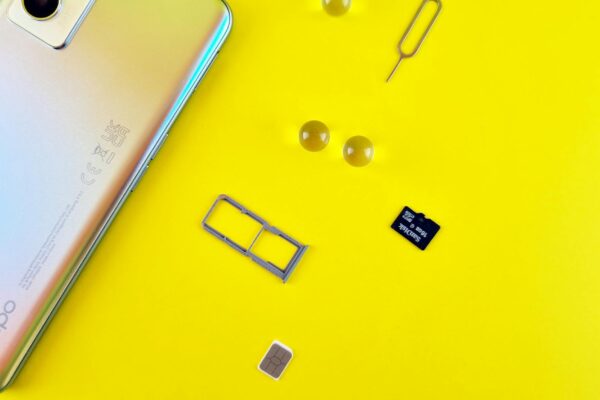 a mobile phone with sim and memory card on yellow surface